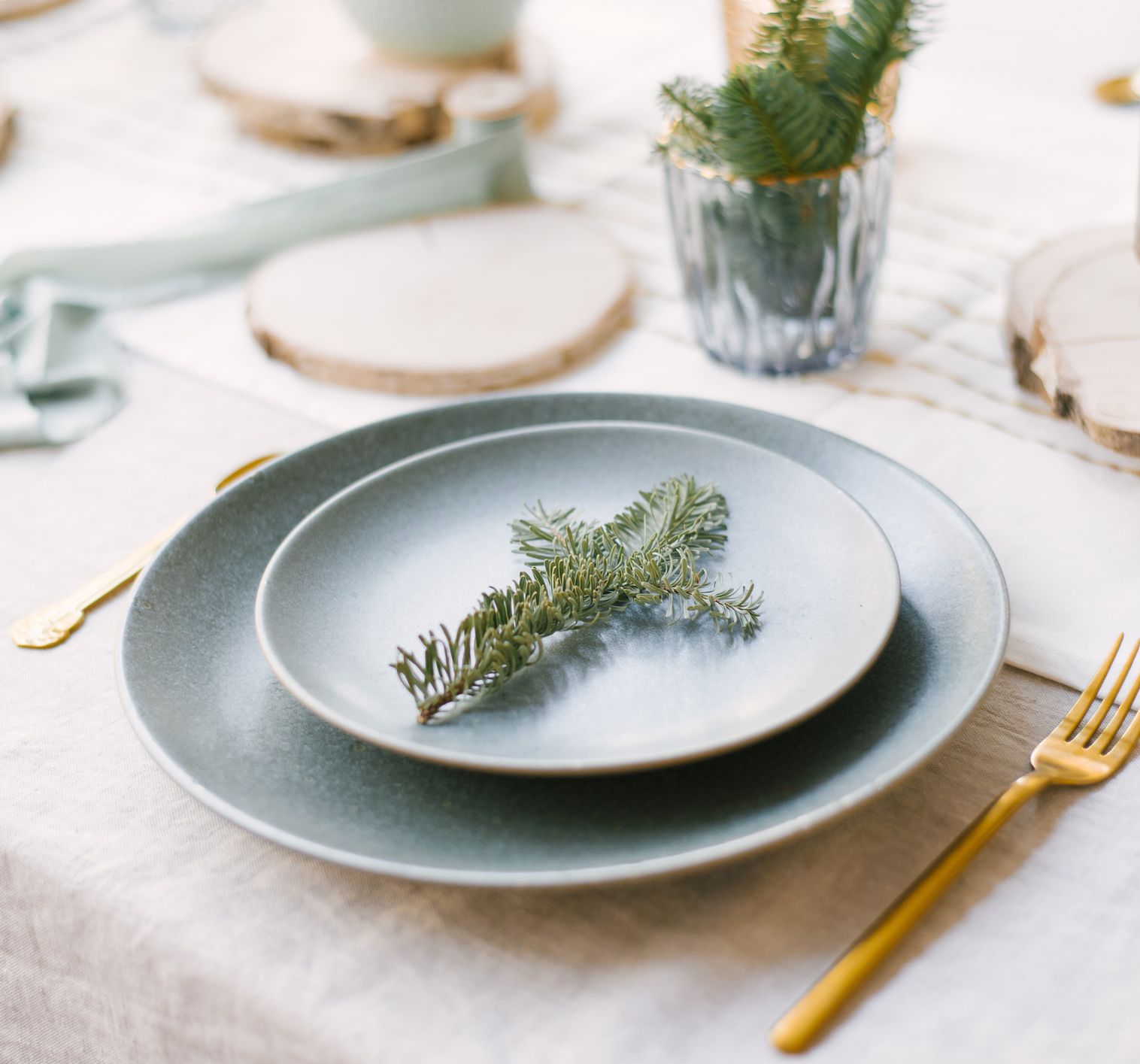 Elegant holiday table setting with pine branch on plate