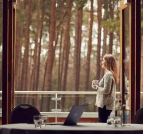Woman on balcony with woodland view