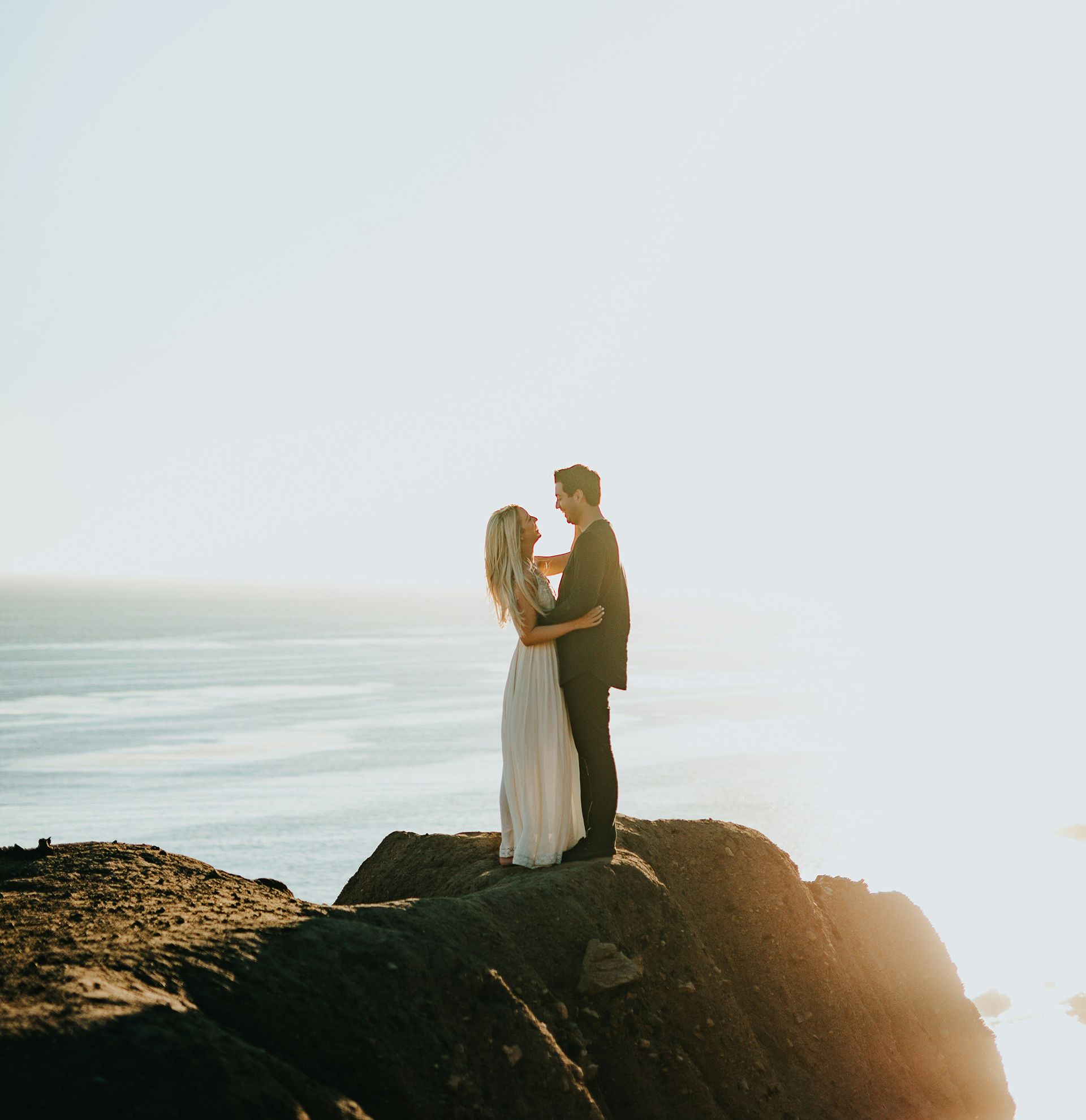 Bride and groom on cliff with sea views