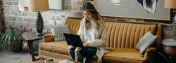 Lady on yellow sofa laptop