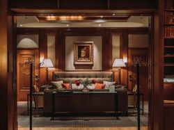 Elegant hotel lounge with vintage decor, a sofa, table, and portrait on the wall.