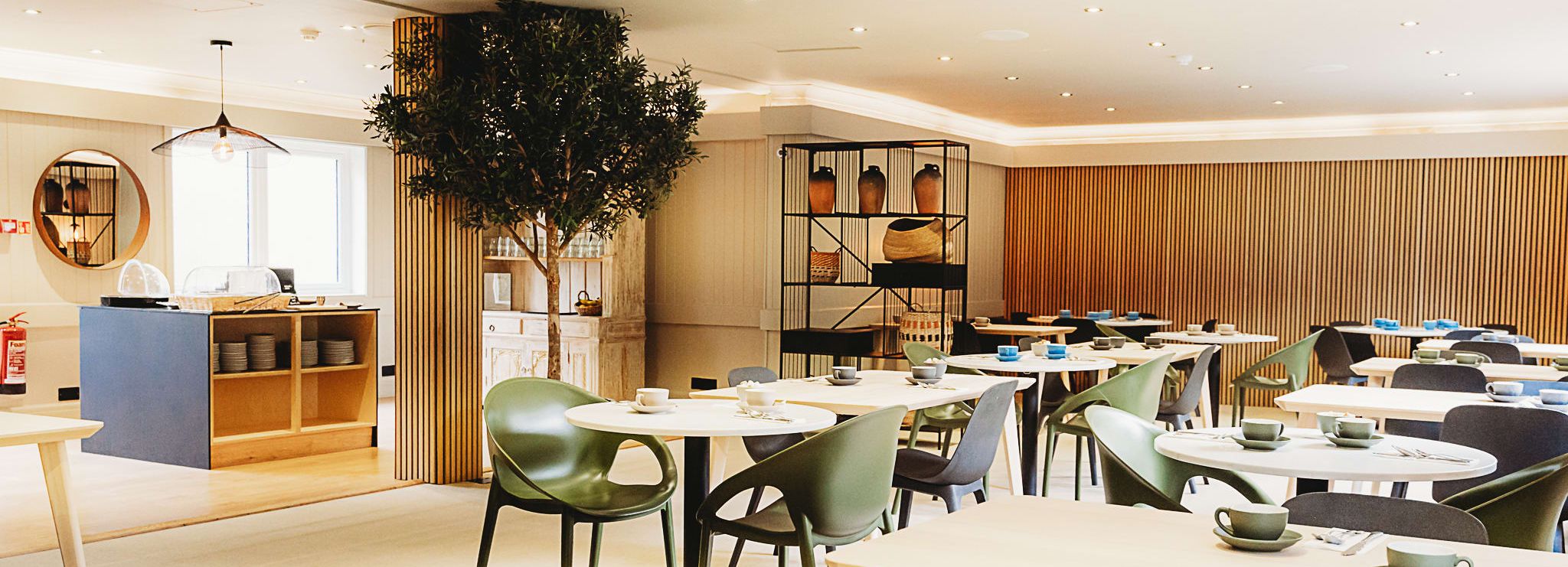 Modern hotel breakfast room with neatly arranged tables and chairs