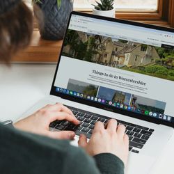 Person using a laptop to browse the Wood Norton website about things to do in Worcestershire.