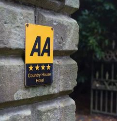 AA-rated country house hotel sign mounted on a stone wall
