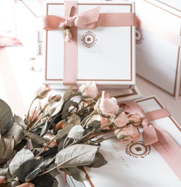 Elegant gift boxes tied with pink ribbons and a bouquet of pale pink roses