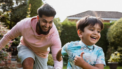 Father and young son playing together outside in a garden