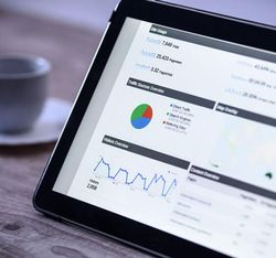 Tablet displaying website analytics dashboard with graphs and charts
