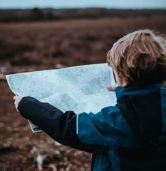 Child holding and looking at a map outdoors