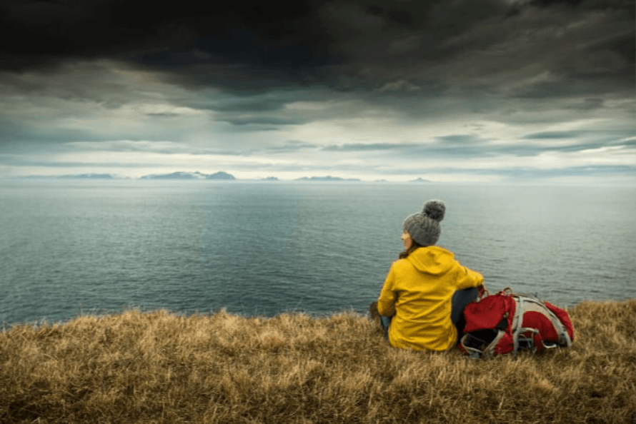 Person sitting alone by a lake