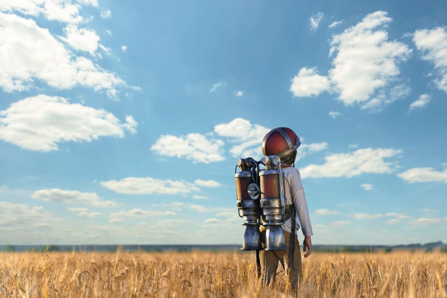 Boy with jet pack in field