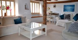 Cozy living room with exposed wooden beams, neutral furniture, and natural light
