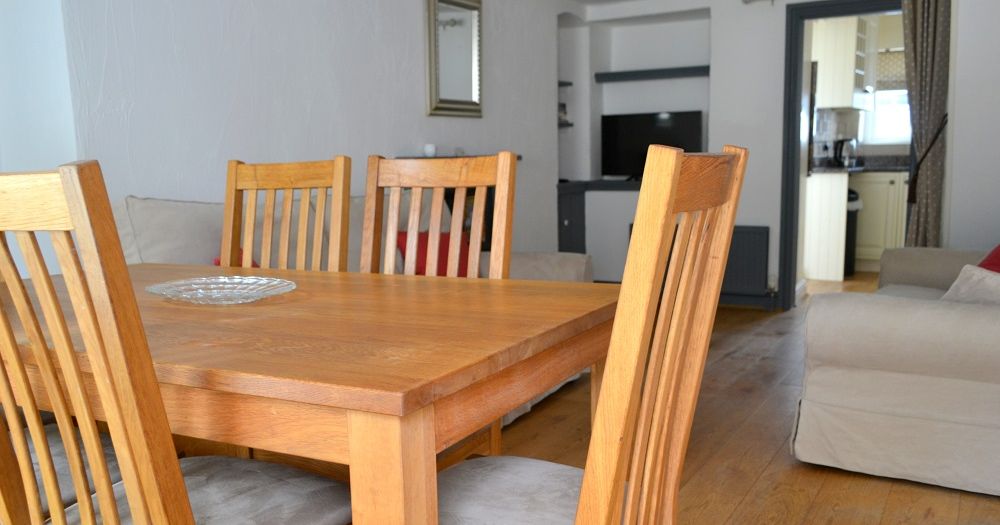 Wooden dining table with four chairs in a modern living and dining room