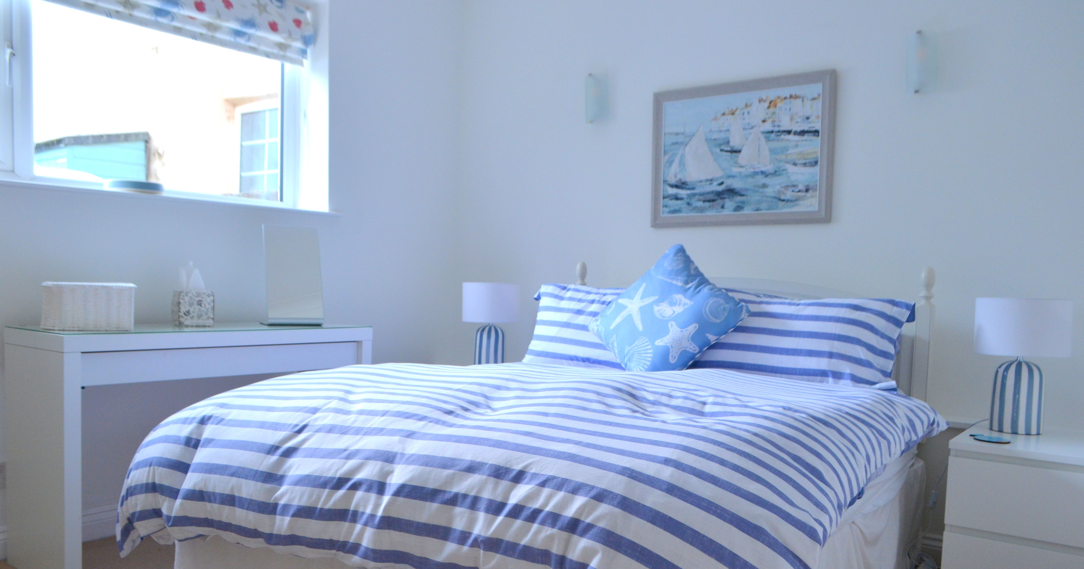 Bright bedroom with nautical-themed blue and white striped bedding