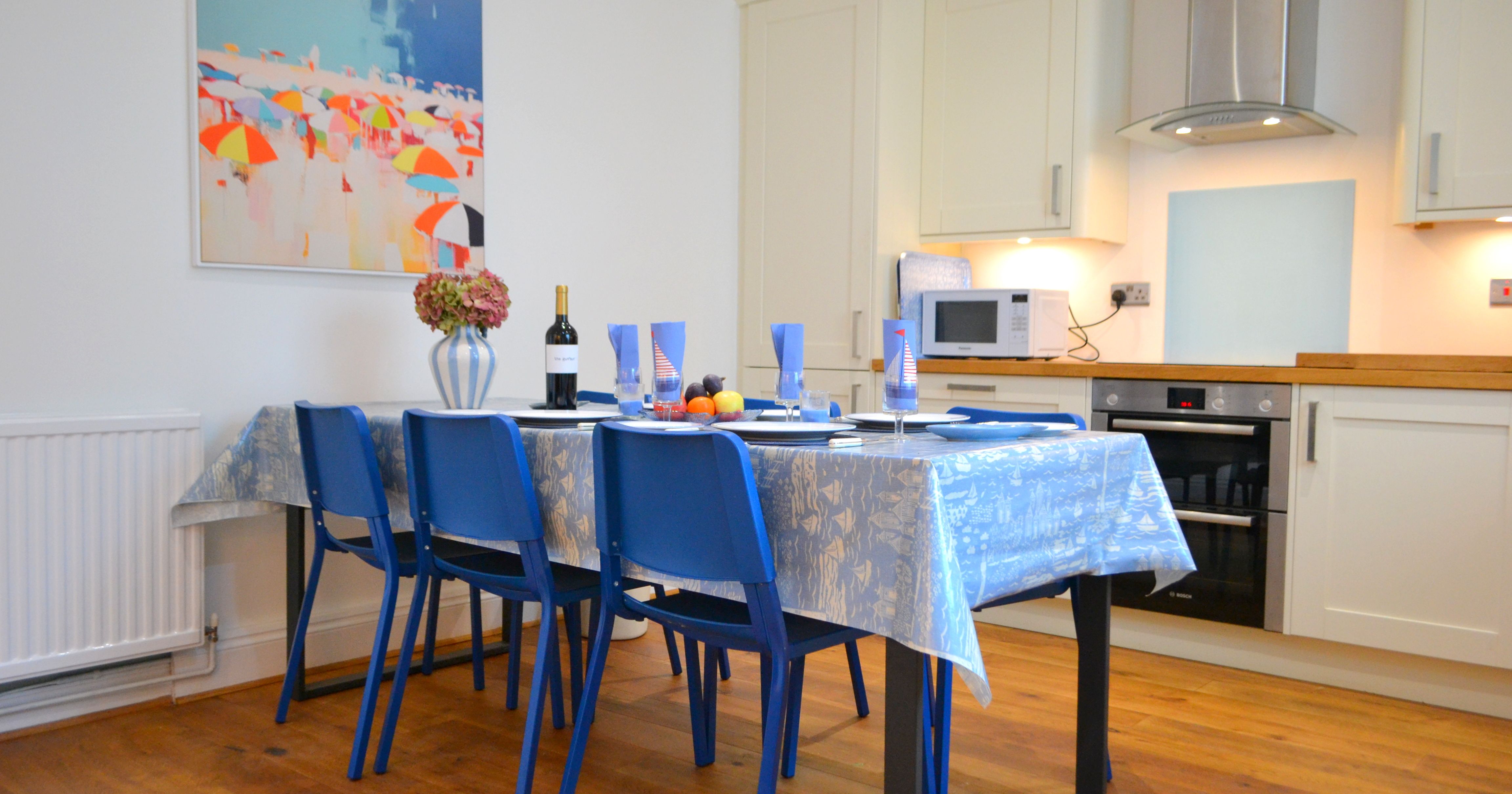 Modern kitchen and dining area with blue chairs and a set table