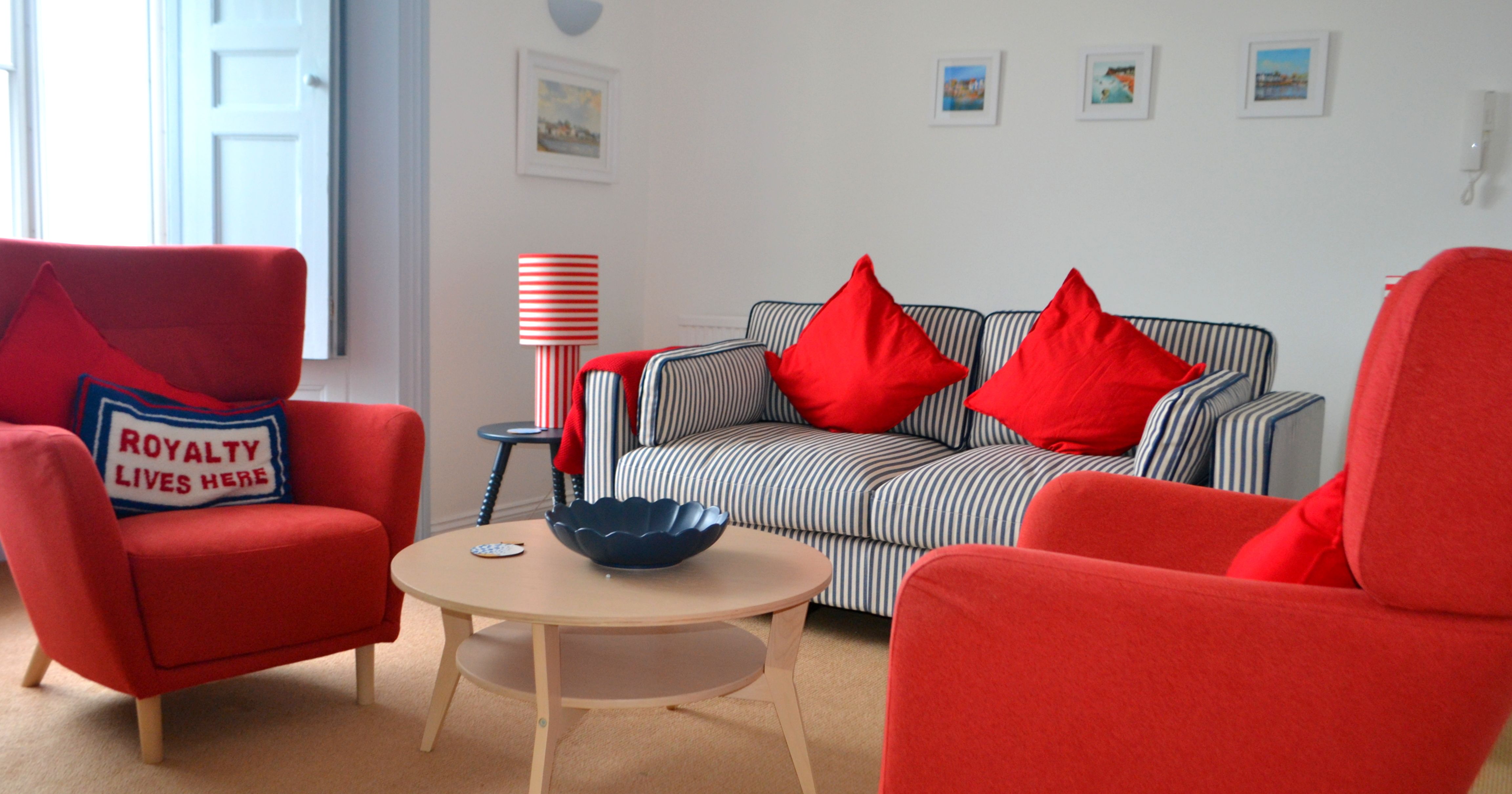 Modern living room with red chairs and striped sofa