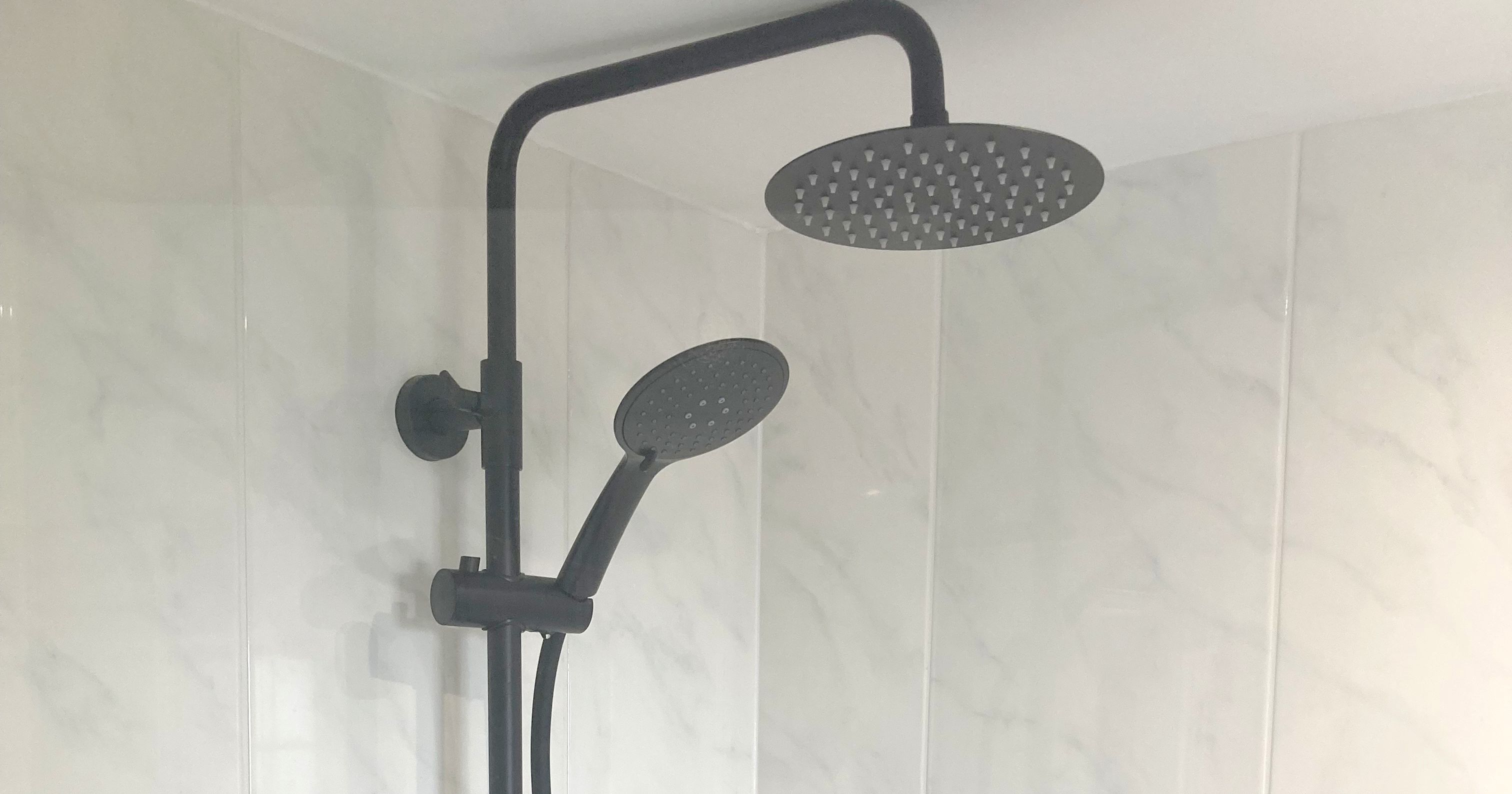 Modern shower with overhead and handheld showerheads in a tiled bathroom