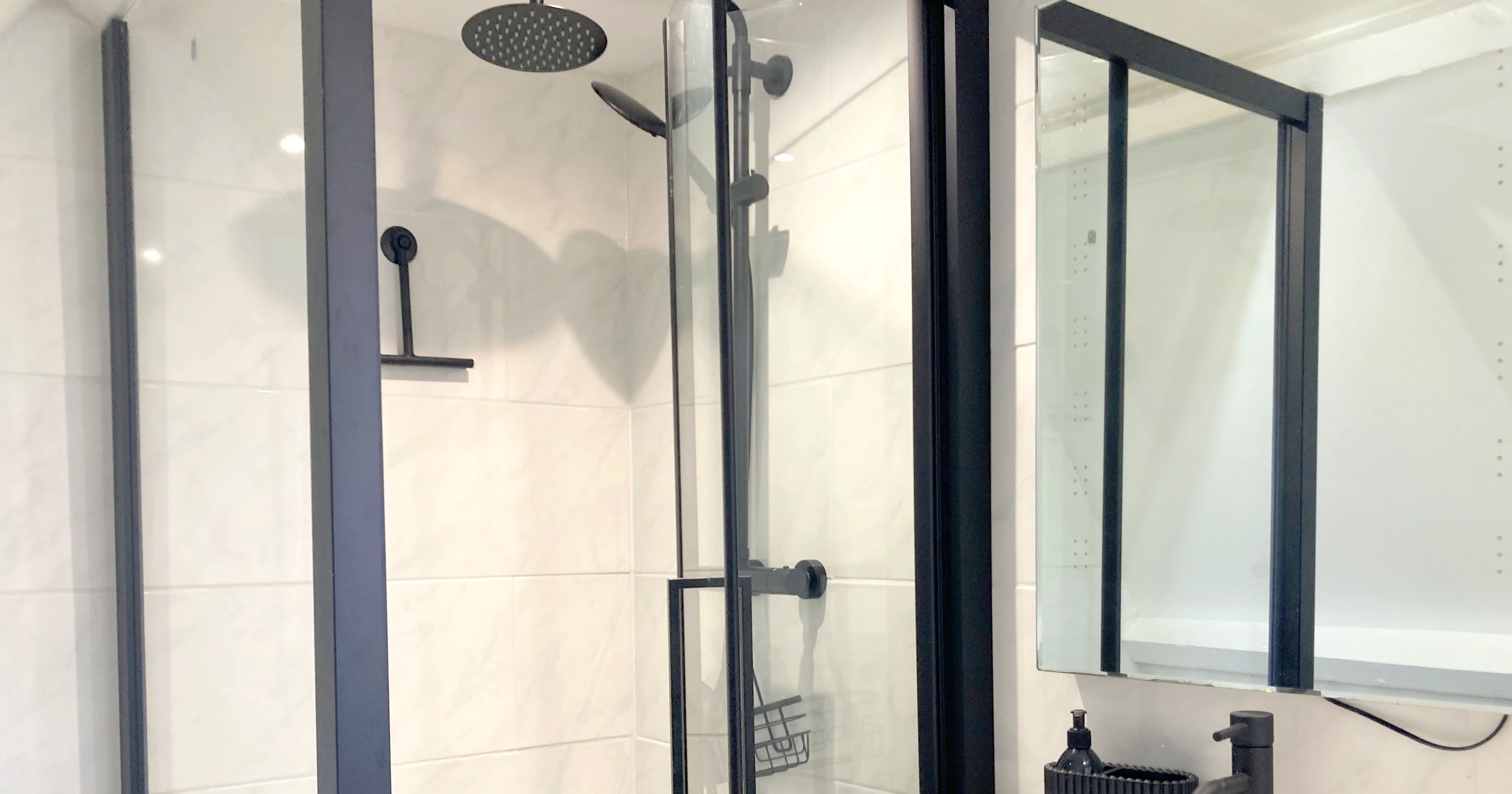 Modern bathroom with glass shower enclosure and black hardware