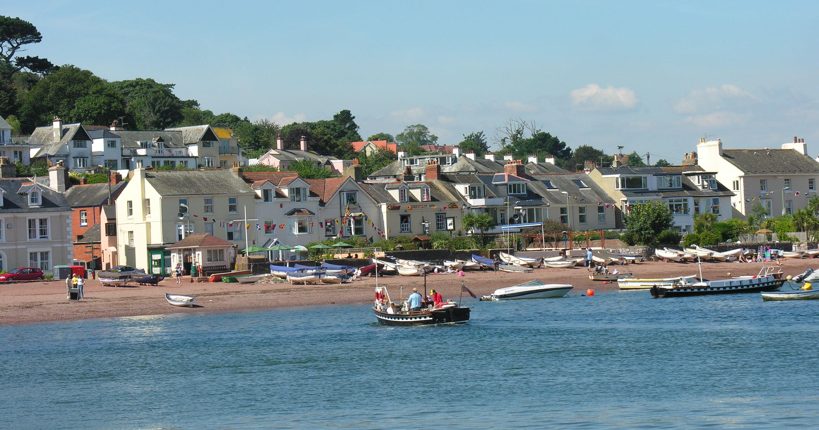 River Teign with boats and houses along a beach on a sunny day