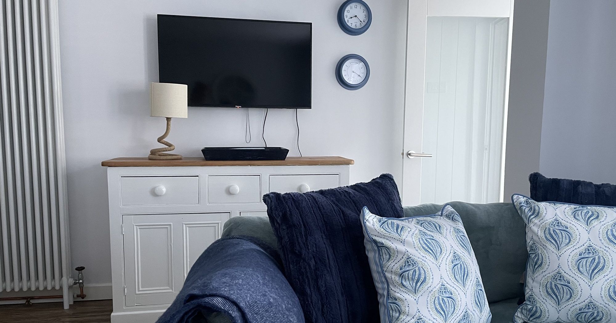 Living room with TV, sofa, and cushions