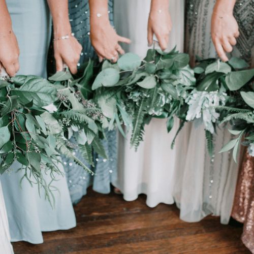 Bridesmaids each holding a pair of bouquet flowers