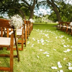 Flowers placed on the grass down the wedding isle
