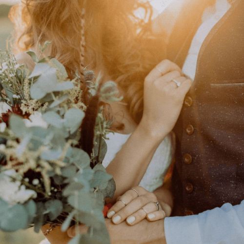 Groom and Bride in the sunset with a bouquet of flowers