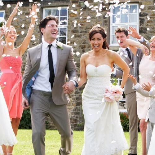 Bride and Groom having confetti thrown over them by guests