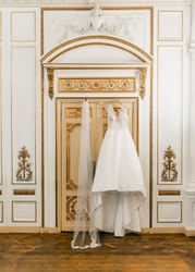 Wedding dress and veil hung on door