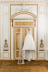Wedding dress and veil hung on door