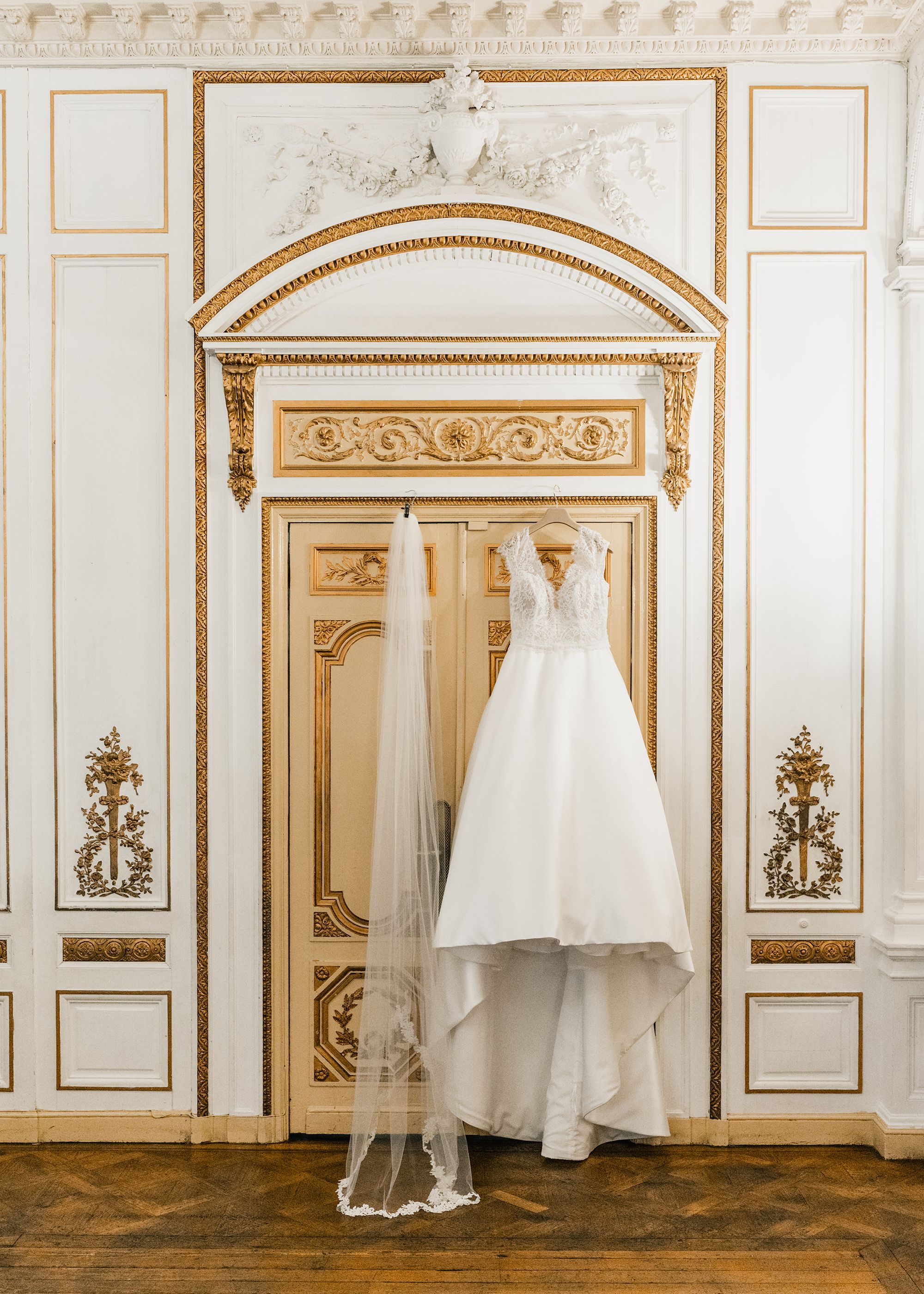 Wedding dress and veil hung on door