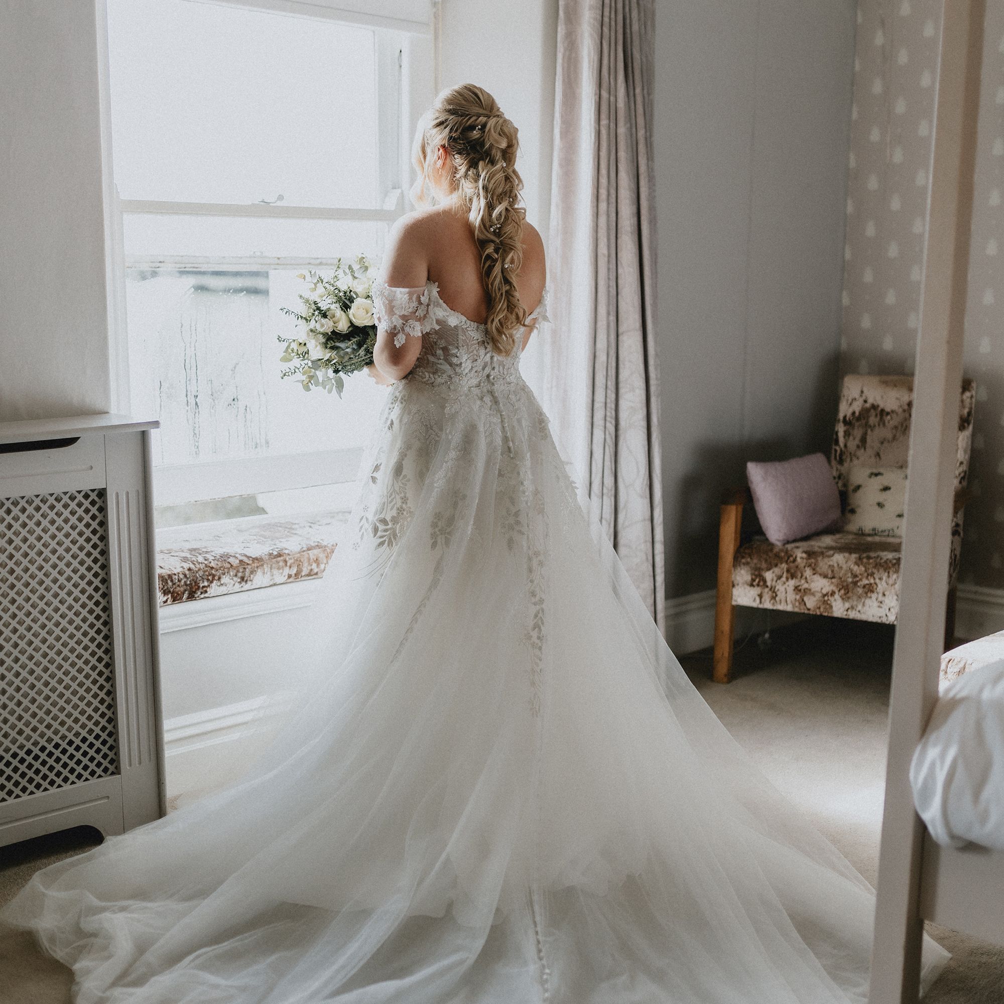 Bride in bedroom by window