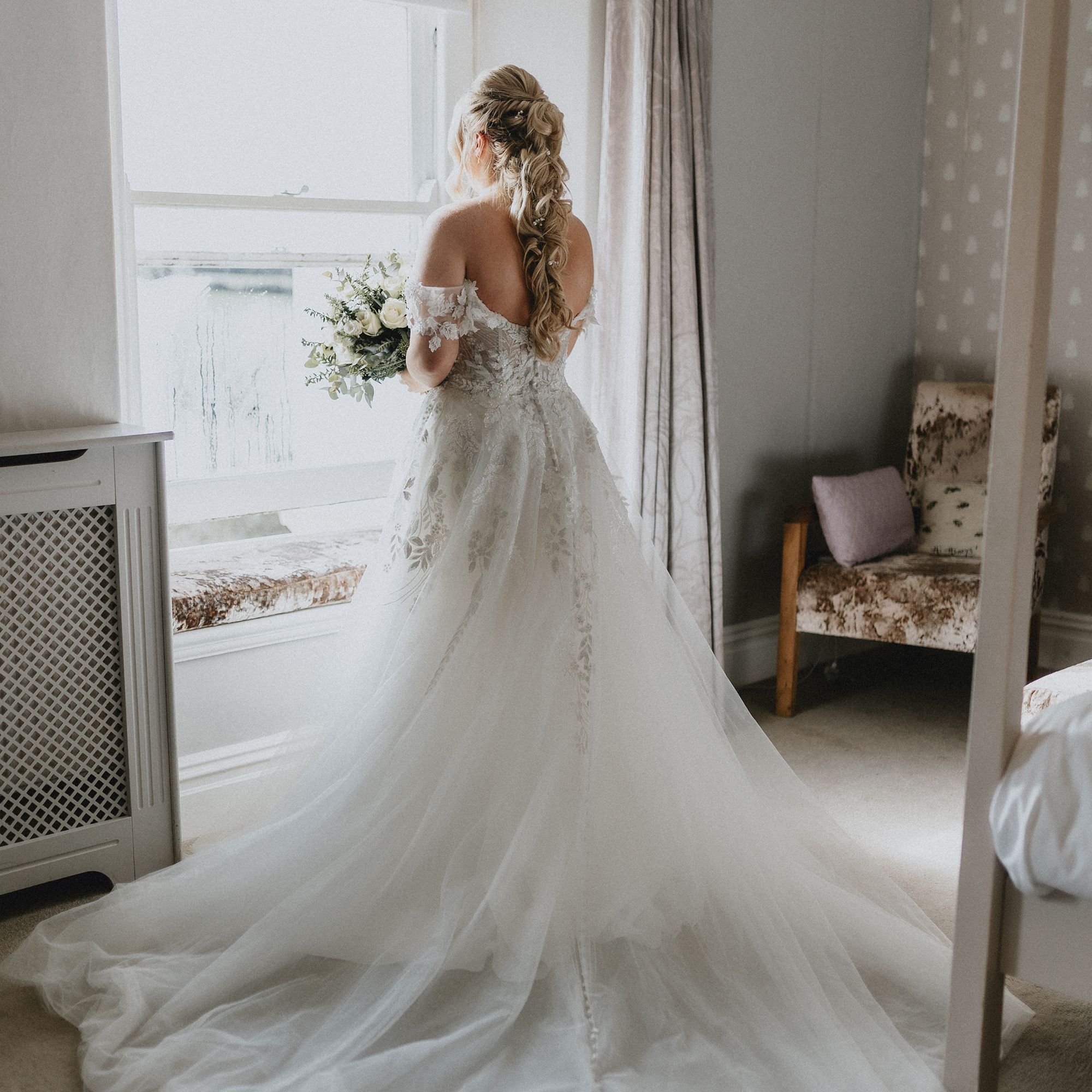 Bride in bedroom by window