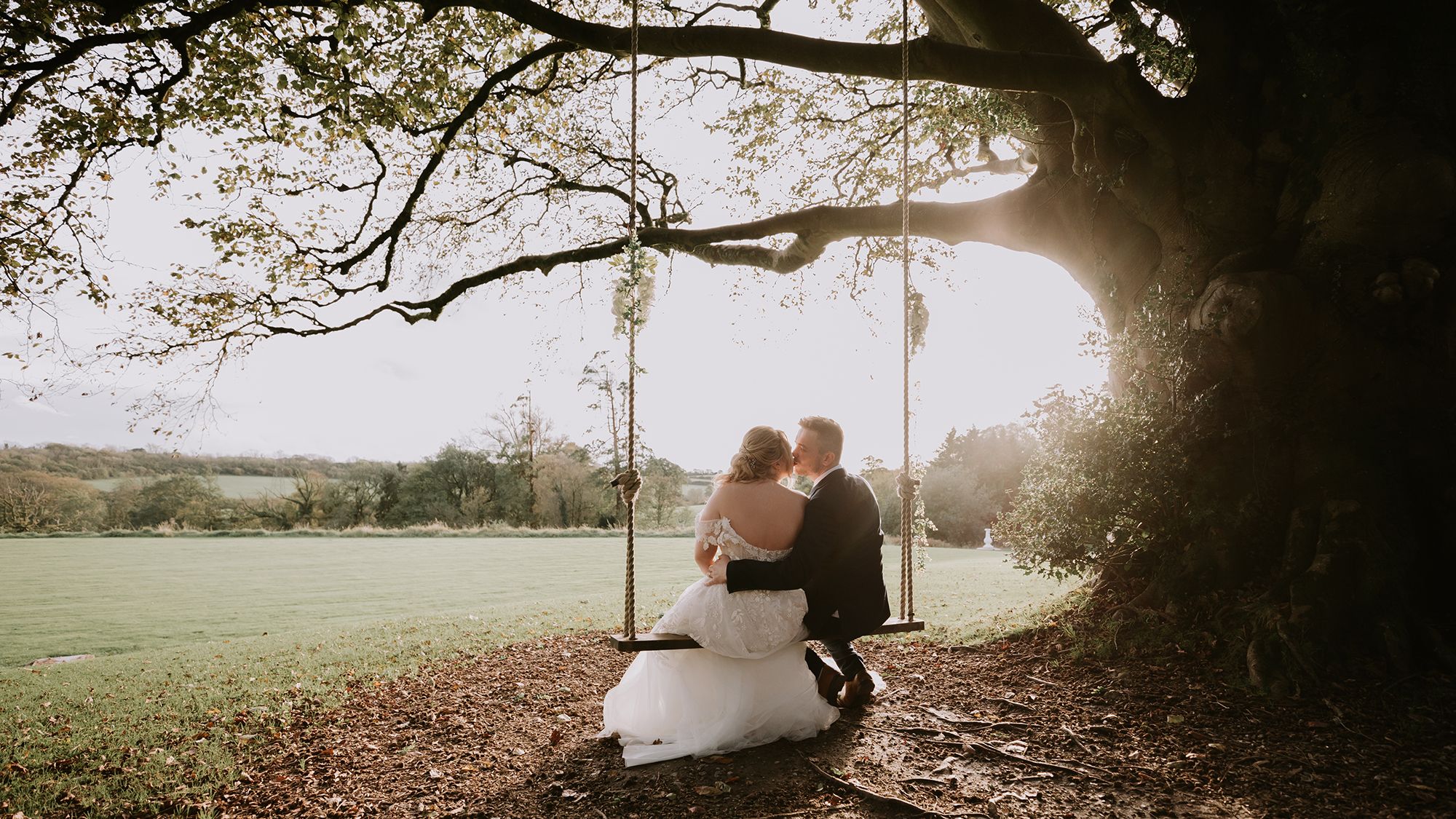 Bride and groom on swing outside