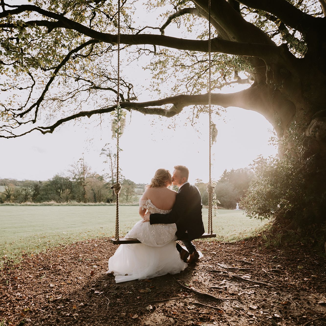 Bride and groom on swing outside