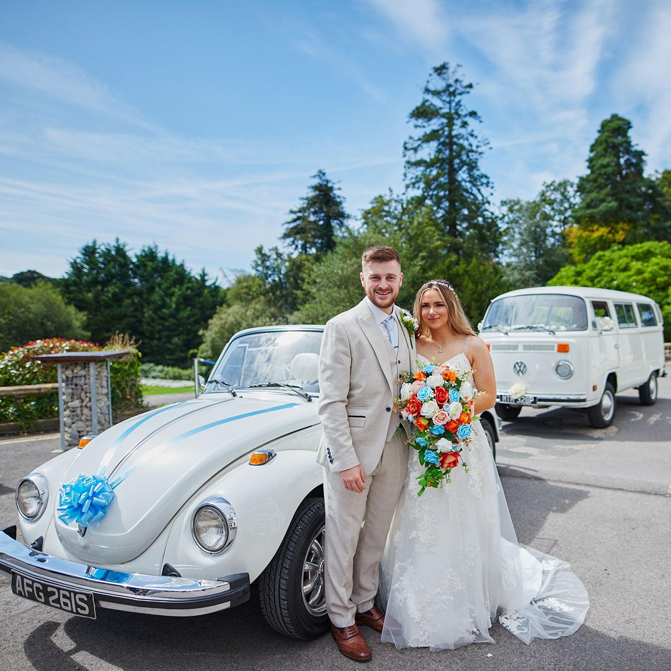 Bride and groom outside by wedding car