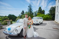 Bride and groom outside by wedding car