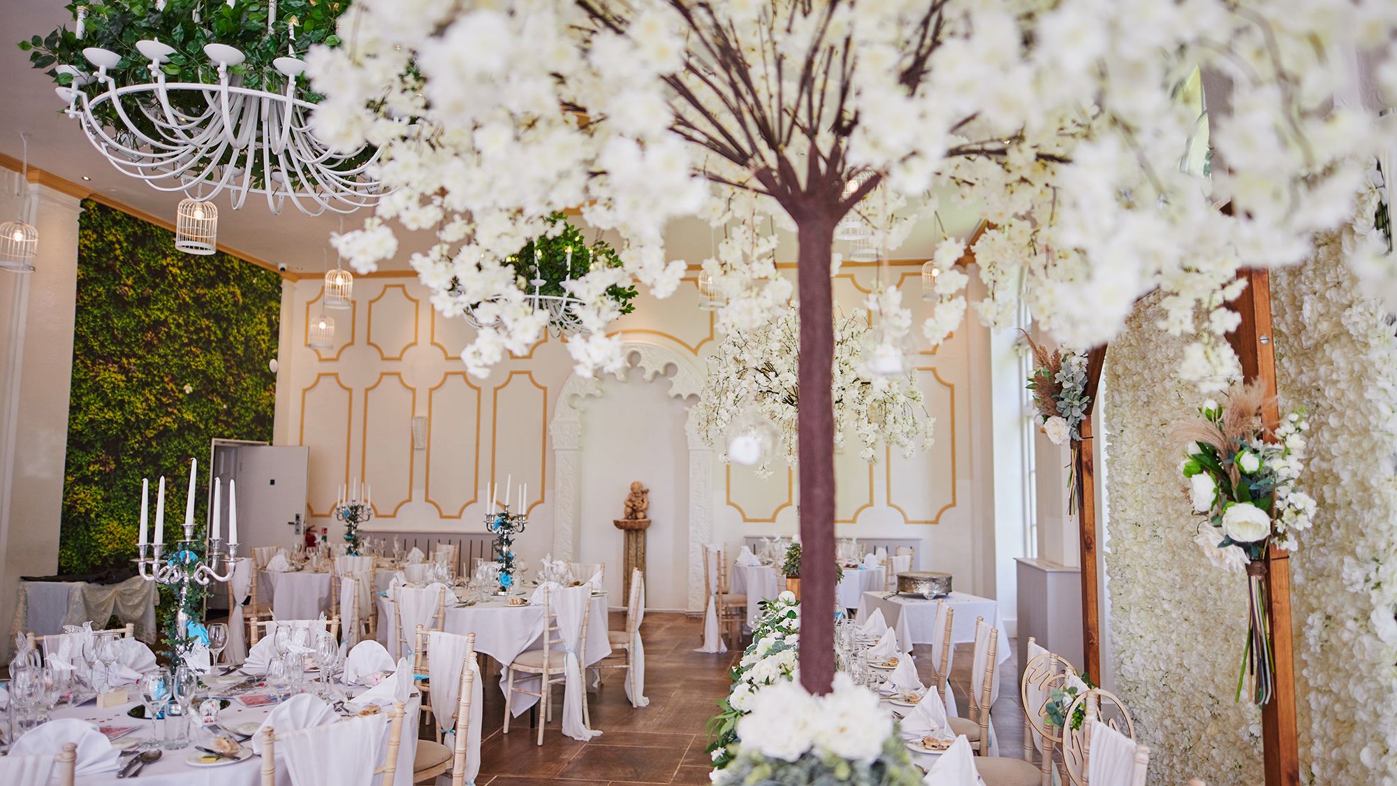 Reception tables set up with white trees