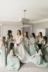 Bride with bridesmaids in bedroom