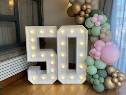 Light-up number 50 with pastel and gold balloon decorations