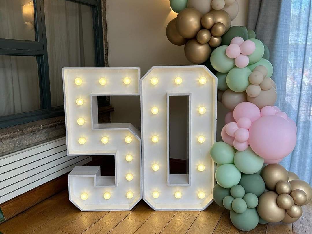 Light-up number 50 with pastel and gold balloon decorations