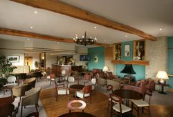Spacious lounge bar with wooden beams, modern furniture, and a cozy atmosphere