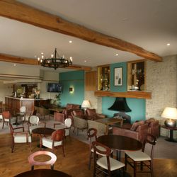 Spacious lounge bar with wooden beams, modern furniture, and a cozy atmosphere