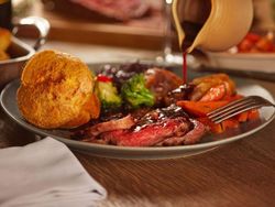 Traditional Sunday roast dinner with beef, Yorkshire pudding, vegetables, and gravy