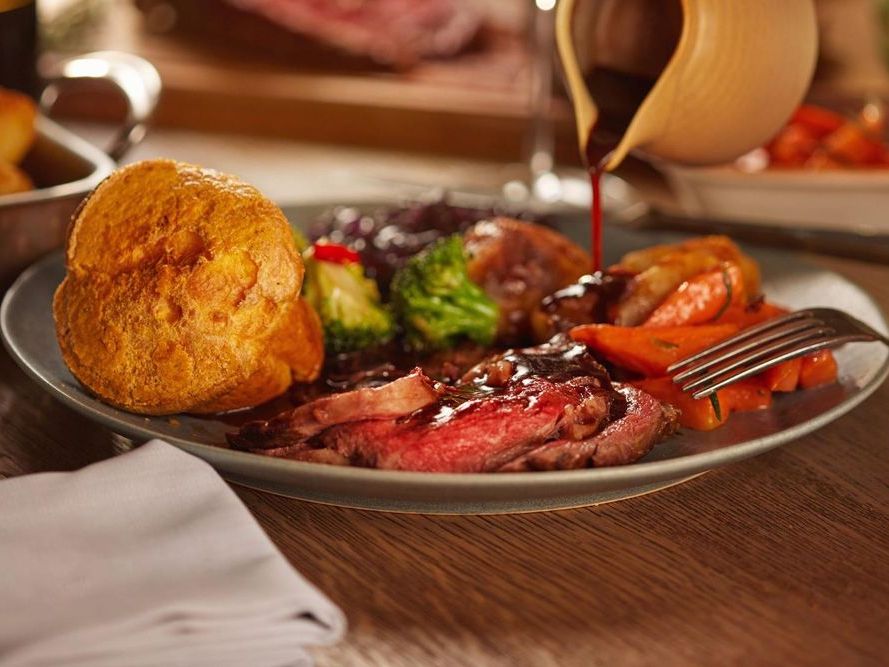Traditional Sunday roast dinner with beef, Yorkshire pudding, vegetables, and gravy