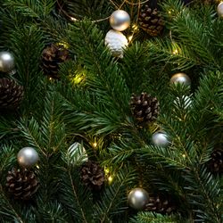 Close-up of decorated Christmas tree branches with pine cones and ornaments