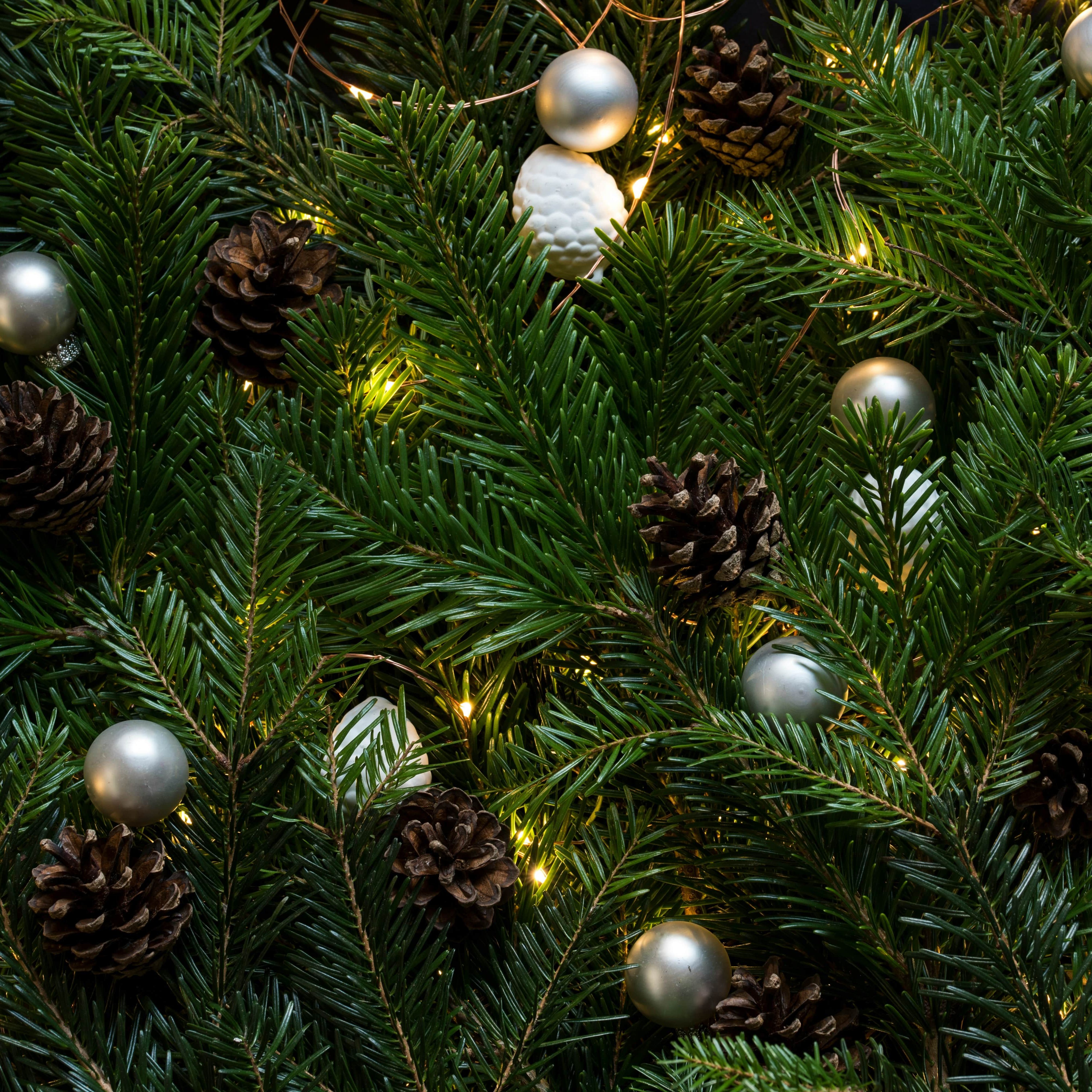 Close-up of decorated Christmas tree branches with pine cones and ornaments