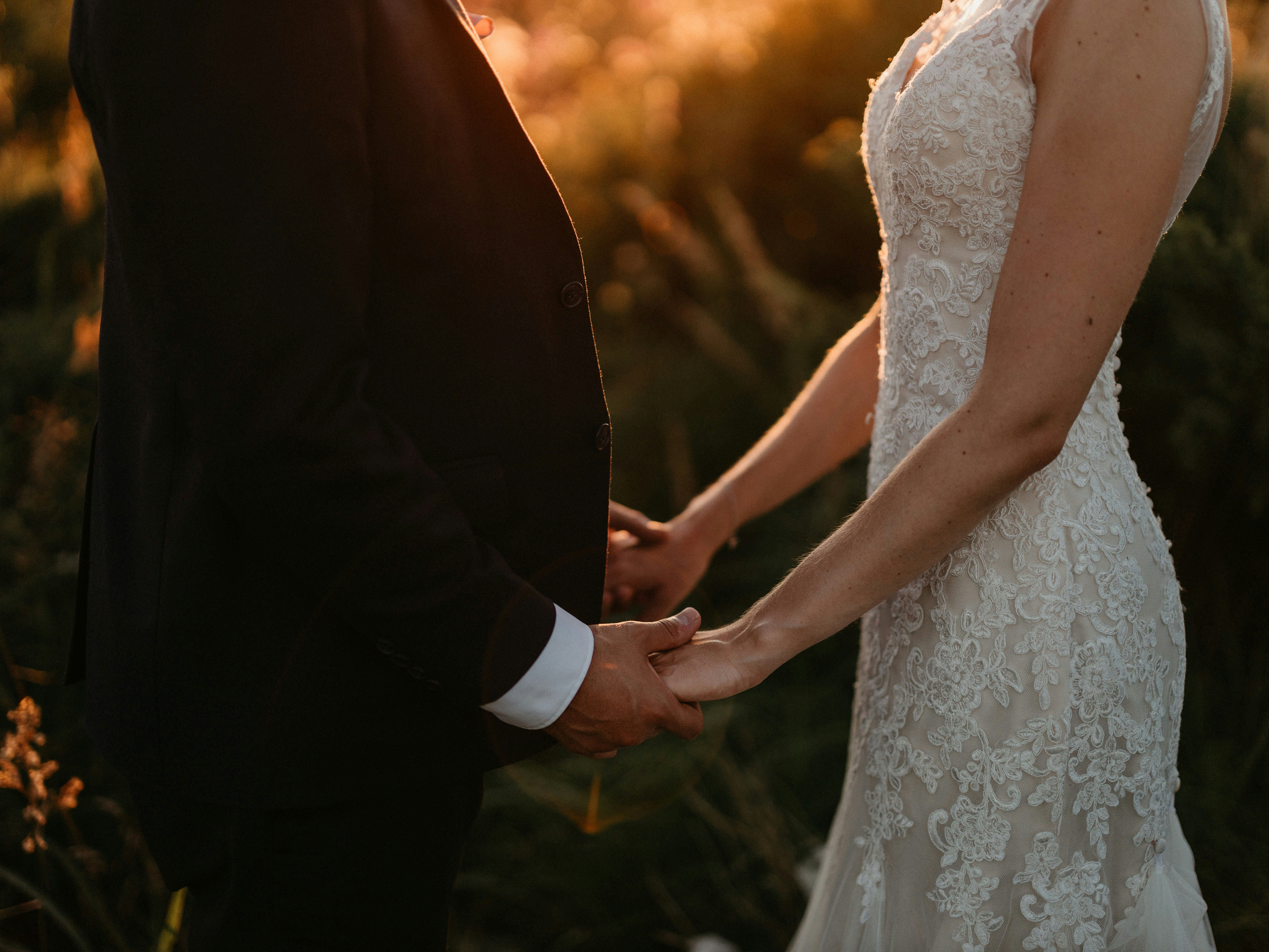 Bride and groom holding hands at sunset