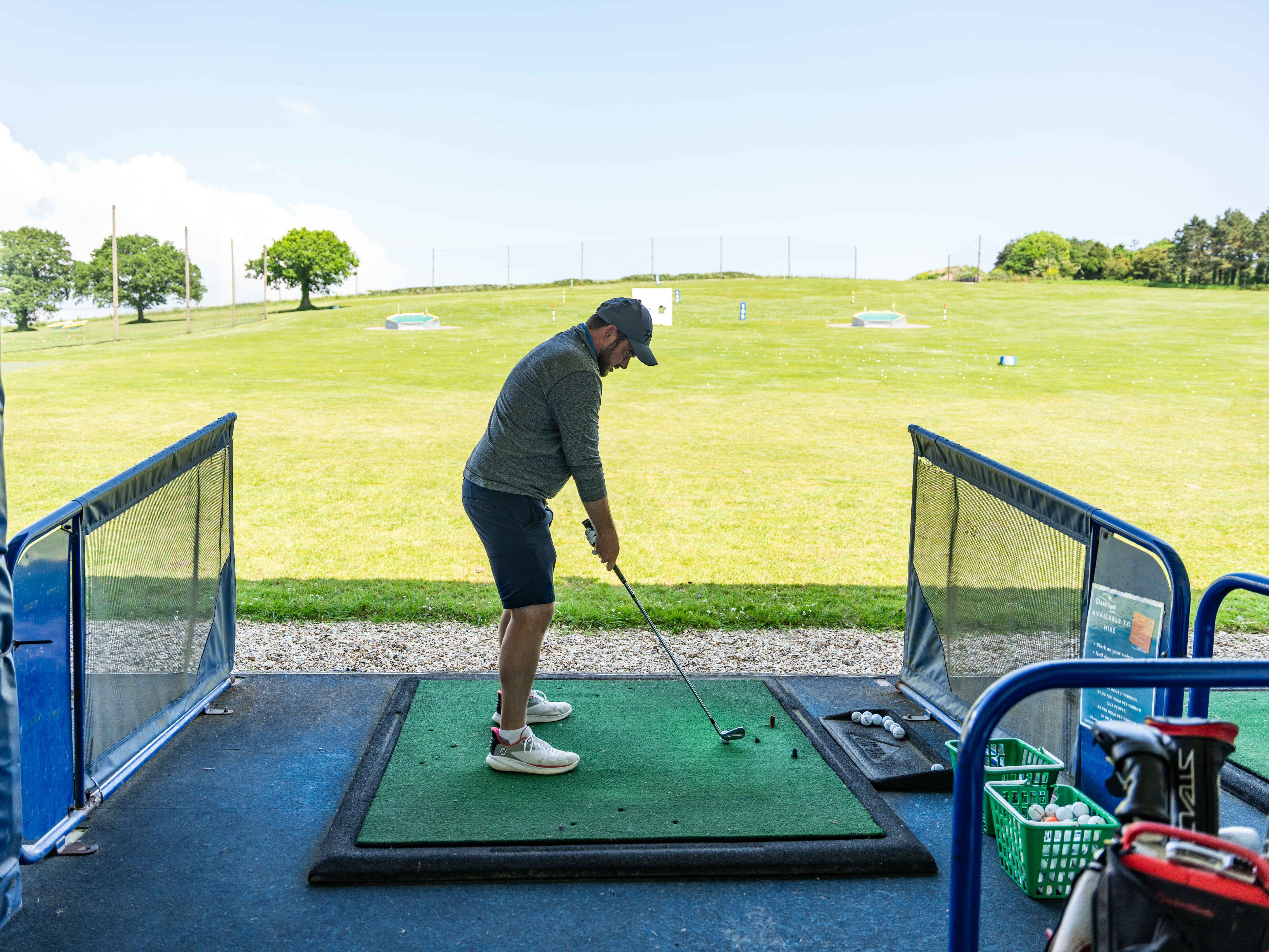 Man practicing golf swing at a driving range