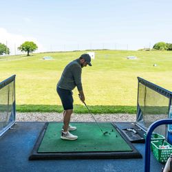 Man practicing golf swing at a driving range