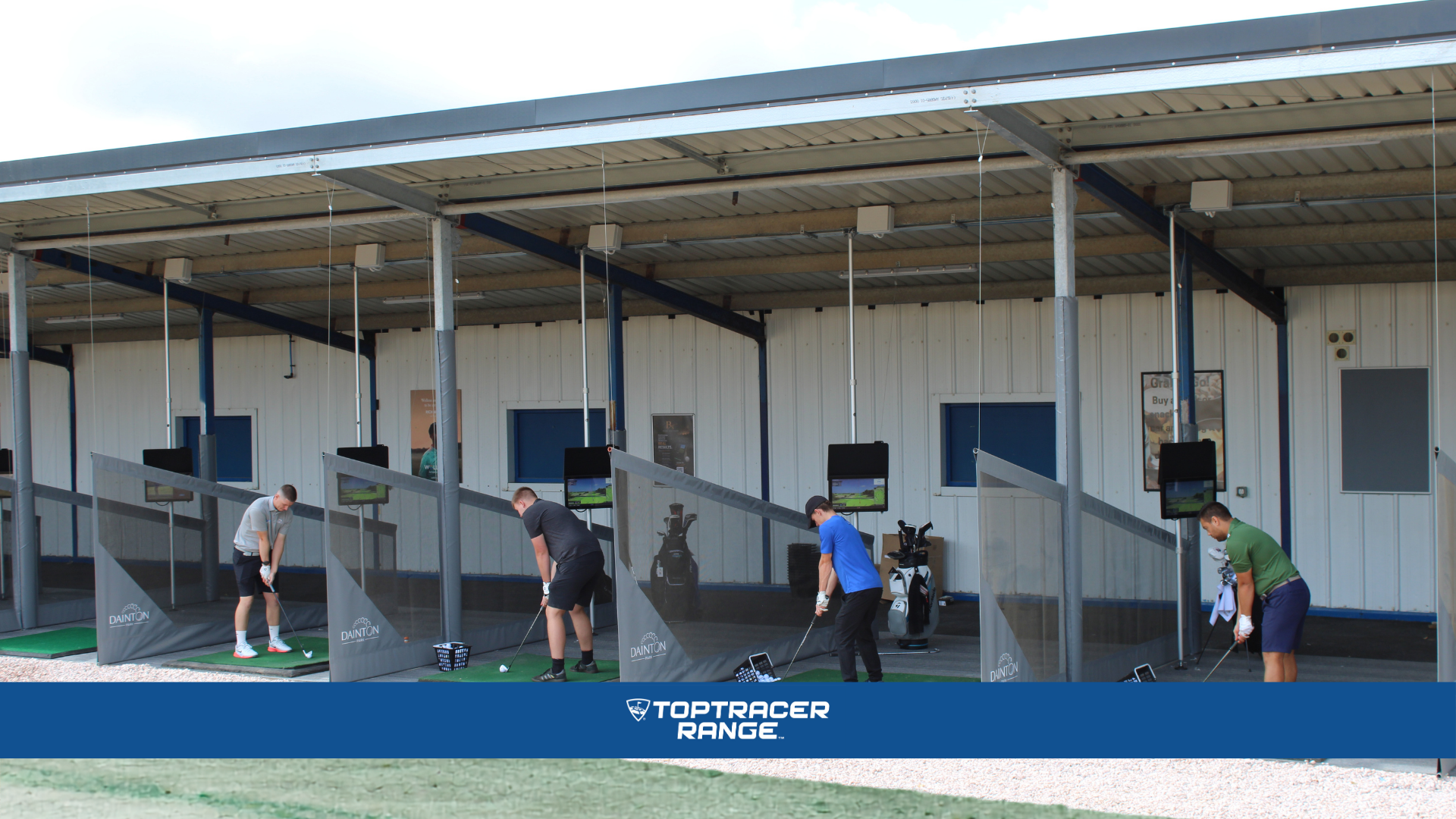 Golfers practising at covered Toptracer Range driving bays